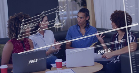 Collaborating coworkers around table in office lounge, with laptops, coffee cups, timeline graphics