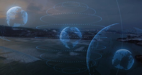 Floating multiple holographic globes illuminating coastal bay at dusk, with glowing blue dot rings