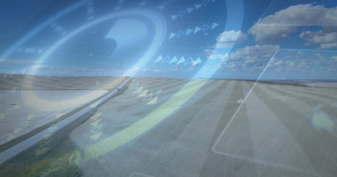 Displaying translucent HUD overlaying rural road across farm fields under blue sky, markers - Powered by Adobe