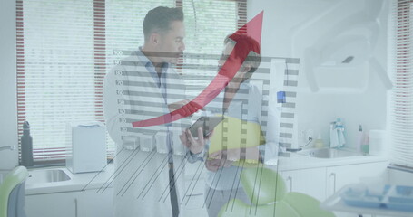 Discussing figures dentist in lab coat by green dental chair in exam room, with tablet computer
