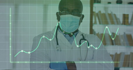 Posing senior doctor wearing mask in clinic, with stethoscope, file shelves and line chart overlay
