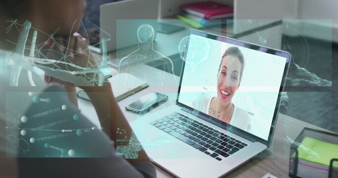 Joining online call mature man sitting at office desk with laptop smartphone and data overlays