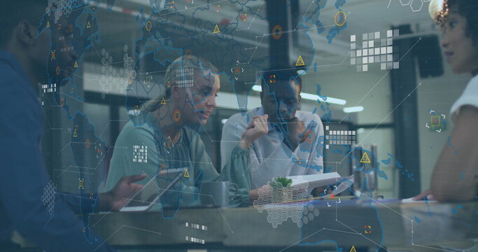 Collaborating four professionals in businesswear reviewing tablet reports in meeting room with mug