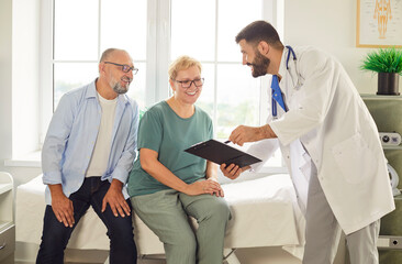 Obraz premium Elderly couple talking with doctor in a bright office, smiling and discussing health. Professional consultation brings comfort. Caring conversation builds trust and understanding. 