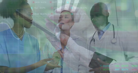 Gesturing medical team analyzing digital charts in clinical hallway, with stylus pen and tablet