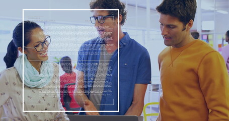 Reviewing laptop screen by three professionals in open-plan office, with digital code overlay