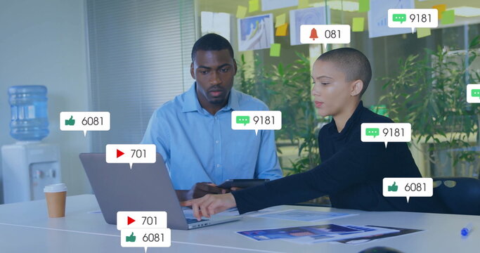 Business team discussing social media metrics on laptop and tablet in meeting room, sticky notes