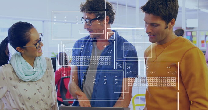 Collaborating three colleagues reviewing data overlays on laptop in open office, digital interface