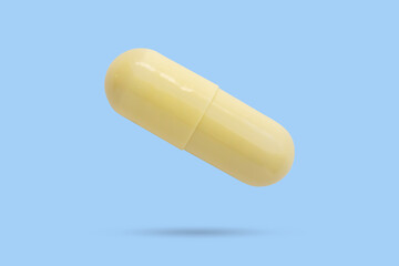 Yellow medicine pill capsule float on blue background