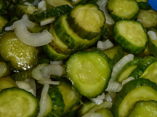 Freshly sliced pickled cucumbers with onions close-up.