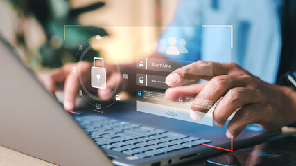 Close-up of hands typing on laptop with digital login interface overlay, username and password fields, and security padlock icon. Concept of cybersecurity and data protection.