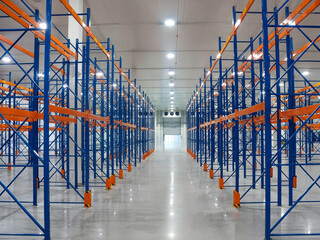 Empty warehouse with metal shelving creating a spacious interior and organized storage.