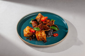 Pan-fried tofu cubes with grilled eggplant, chicken, chili pepper and fresh herbs in spicy Korean...