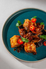 Pan-fried tofu cubes with grilled eggplant, chicken, chili pepper and fresh herbs in spicy Korean...