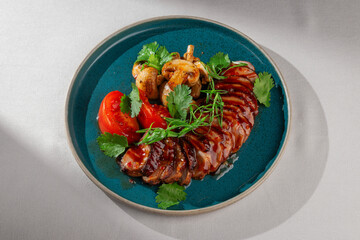 Sliced glazed duck breast served with grilled mushrooms, fresh tomatoes, cilantro and green onions...