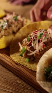 Hands Arranging Grilled Soft Shell Tacos on Wooden Board