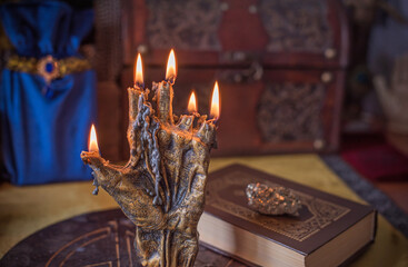Enchanted ritual altar with burning candle, mystical hand, and ancient grimoire on golden cloth