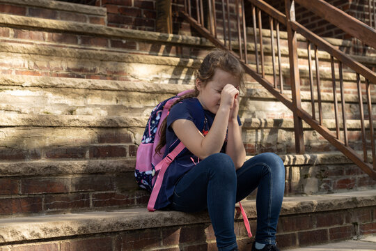 Little girl sitting on brick steps