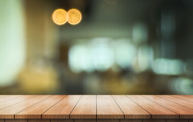 Empty wooden table top with lights bokeh on blur restaurant background.