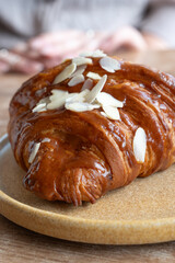 Closeup of a delicious almondtopped croissant on a plate