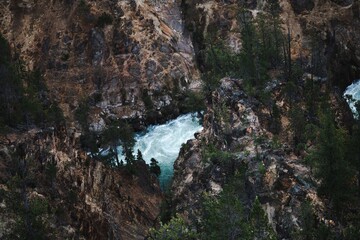 Rugged canyon with flowing river and lush greenery.