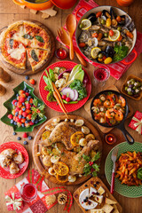 Fototapeta premium 【クリスマステーブルイメージ】ローストチキン。アクアパッツァ。ポトフ。アヒージョ。クリスマスパーティーの賑やかなテーブルイメージ。