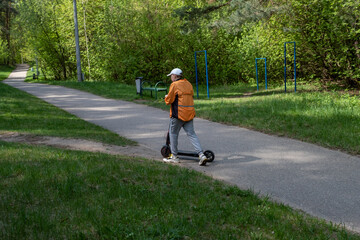 boy riding electric scooter in park