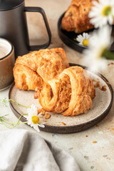 Delicious fresh croissants on ceramic plate and a cup of coffee, croissant with sweet feeling. Morning meal and breakfast concept