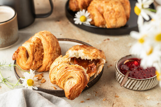 Delicious fresh croissants on ceramic plate and a cup of coffee, broken croissant with sweet feeling. Morning meal and breakfast concept - Powered by Adobe