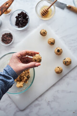 Woman preparing homemade energy ball bites before the gym. 