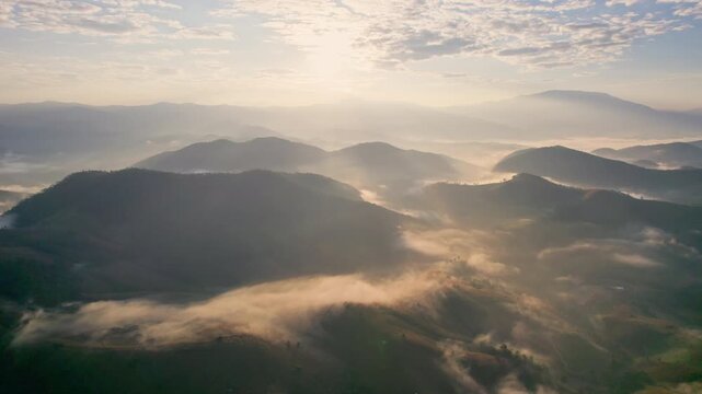 Aerial view of sunlight shines over barren deforest mountain with foggy among agricultural area in countryside at Chiang Mai, Thailand