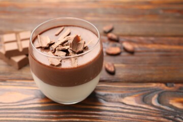 Delicious panna cotta with chocolate on wooden table, closeup. Space for text