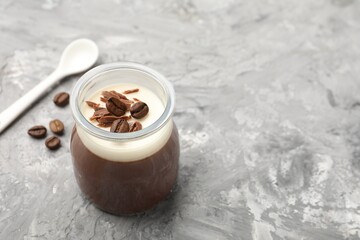Delicious panna cotta with chocolate chunks and coffee beans on grey textured table. Space for text