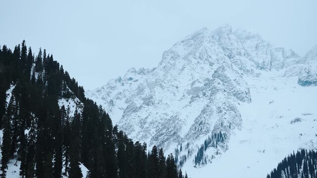 4K shot of snowy Himalayan mountain peak during a winter storm with dark clouds in sky as seen near Thajiwas Glacier in Sonmarg, Jammu and Kashmir, India. Scenic view of the Himalayas in winter.