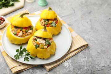 Tasty stuffed pattypan squashes on grey textured table, closeup