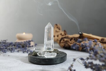 Aura. Different crystals, lavender, burning candle and Palo Santo on white textured table