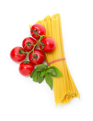 Raw spaghetti pasta, tomatoes and basil isolated on white, top view