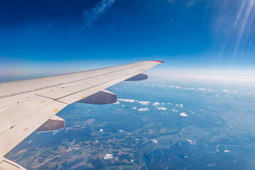 View from the airplane window at a beautiful cloudy sky and the airplane wing