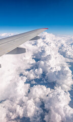 Obraz premium View from the airplane window at a beautiful cloudy sky and the airplane wing