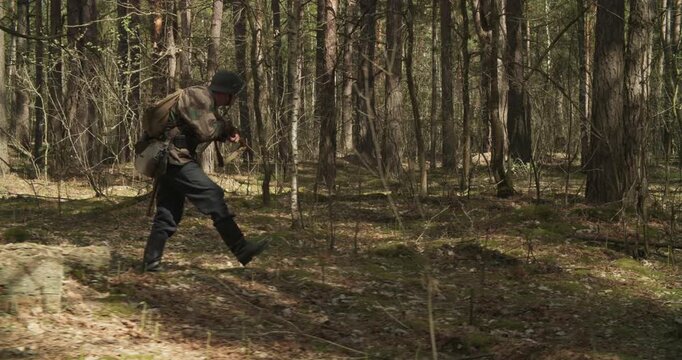 Group Of Soldiers With Carabines Mauser 98k Sneaking Through Forest. Soldier Aiming From Rifle. Wermacht Military Uniform. Reenactors Dressed As German Infantry Soldiers Make War Ambush In Forest
