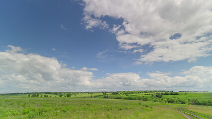 A Beautiful Vibrant Green Landscape Surrounded by Blue Skies and Fluffy White Clouds