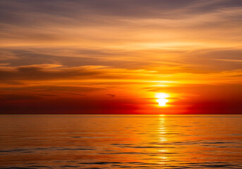 Fototapeta premium vibrant ocean sunset with golden reflections on calm water