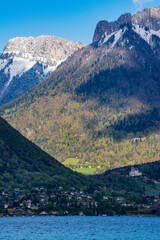 France, Europe: panoramic view of Lake Annecy and the surrounding mountains in the French Alps with the famous castle Chateau de Menthon-Saint-Bernard in the background