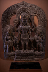 Ancient carved stone statue with sacred figures of Hindu divine family, reflecting centuries of Himalayan artistry.