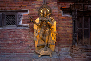 Close-up look of a Tibetan Buddhist woman deity in gold statue, symbolizing protection and the destruction of evil spirits.