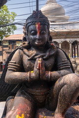 Close-up view of a Tibetan Buddhist man deity as a stone statue, symbolizing protection and the destruction of evil spirits.
