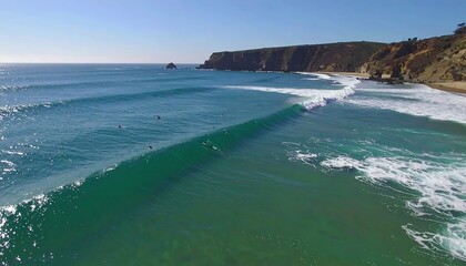Surfers on ocean waves at sunny coastline