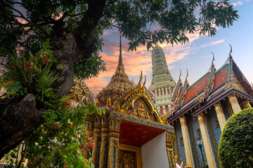 View of several temples at sunset in the Wat Po Buddhist complex in Bangkok, Thailand