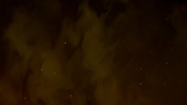 Fond sombre avec fum&eacute;e brune diffuse et fines particules dor&eacute;es en suspension cr&eacute;ant une ambiance myst&eacute;rieuse et &eacute;l&eacute;gante avec espace n&eacute;gatif copyspace