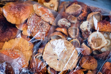 Dried Amanita Mushrooms in Plastic Packaging at Market. Close-up of dried amanita mushrooms in transparent packaging, displayed for sale at a local market